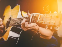 Photo of a guitarist playing their instrument.